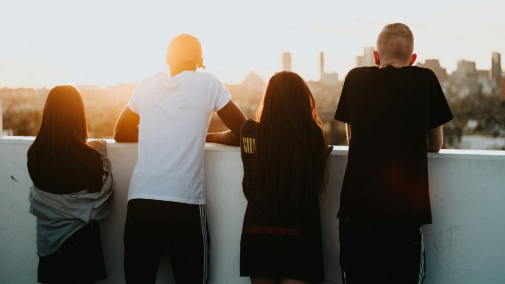 Four young people on a rooftop looking at the sunrise
