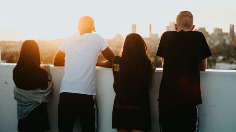 Four young people on a rooftop looking at the sunrise